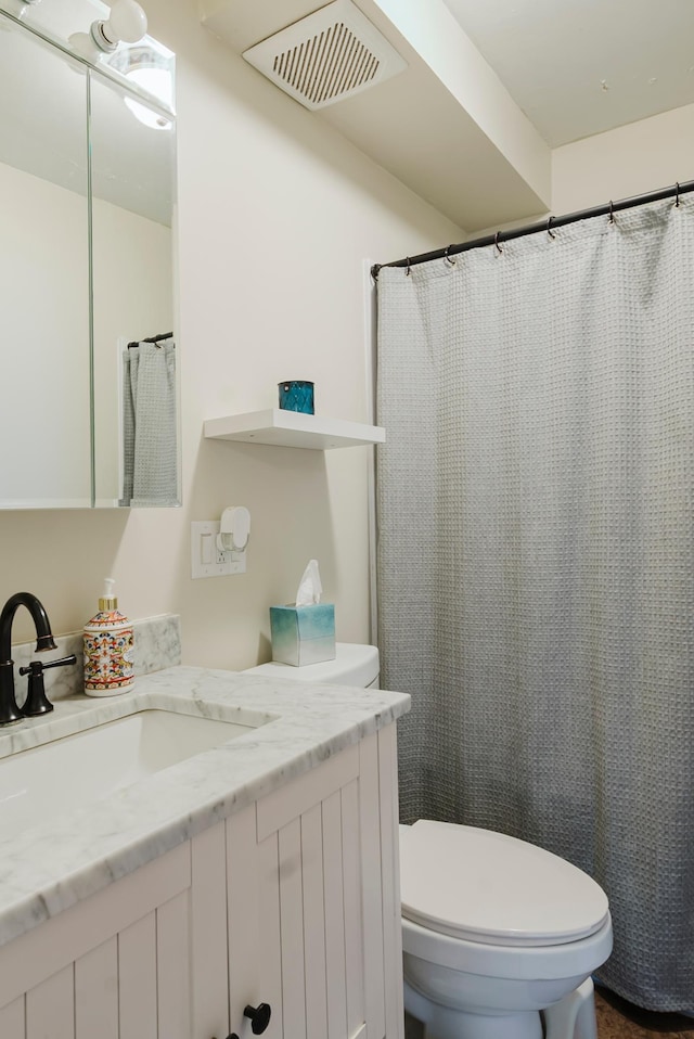 bathroom with toilet, visible vents, and vanity