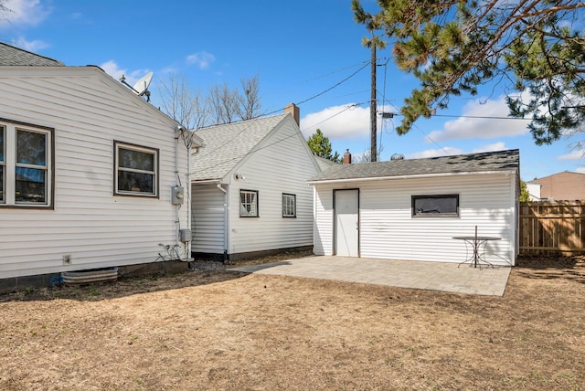 rear view of house with fence and a patio