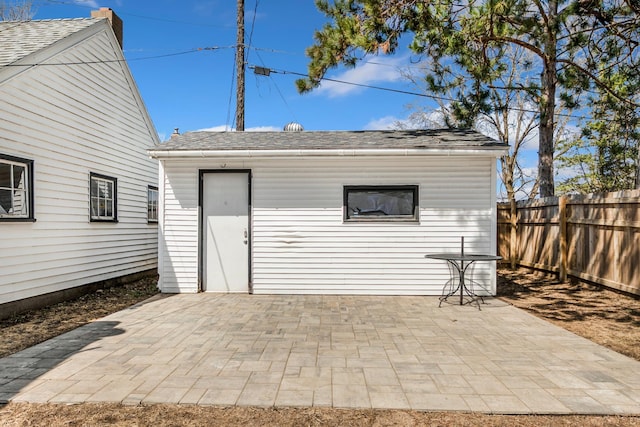 view of patio with fence and an outbuilding