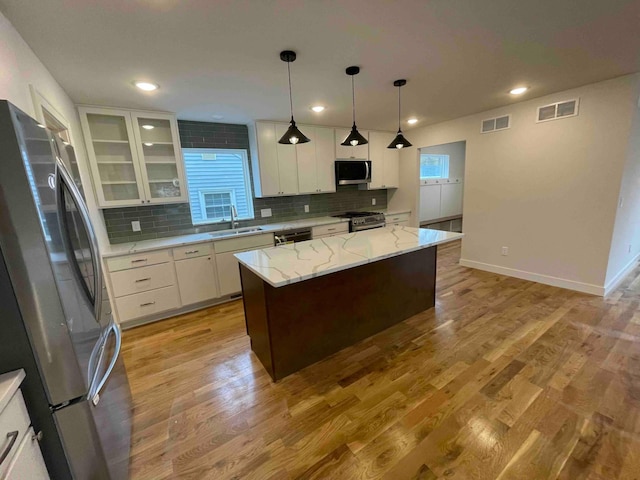 kitchen featuring visible vents, a sink, appliances with stainless steel finishes, and tasteful backsplash