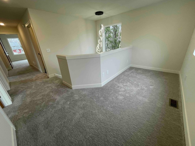 spare room featuring carpet floors, baseboards, and visible vents