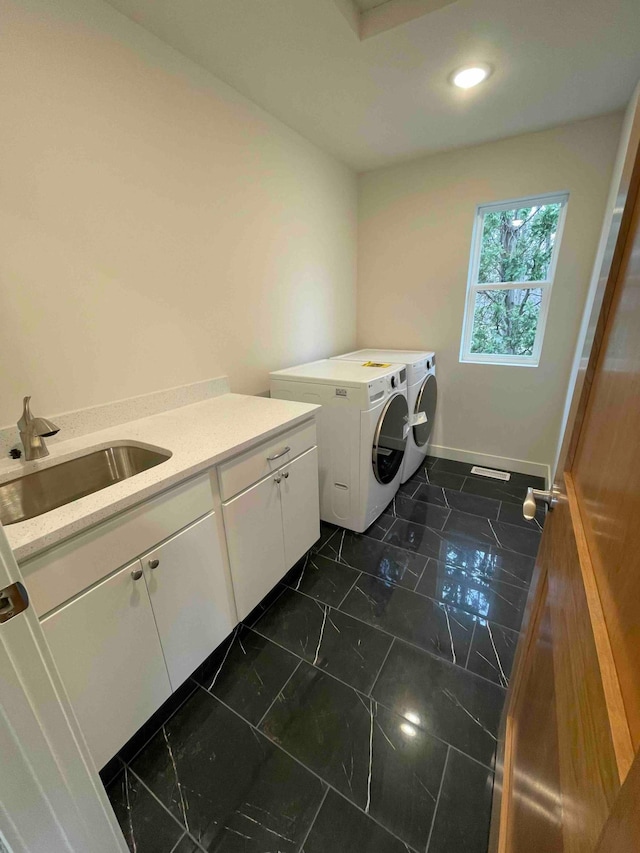 clothes washing area with baseboards, recessed lighting, a sink, cabinet space, and independent washer and dryer