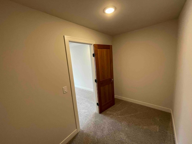 hallway featuring baseboards and carpet flooring