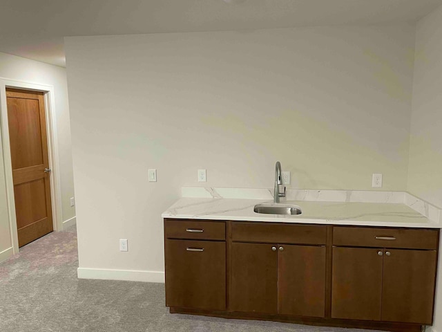 interior space with baseboards, light colored carpet, and a sink