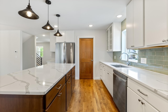 5345 45th Ave S, Minneapolis, MN 55417 - kitchen with appliances with stainless steel finishes, light wood-style flooring, a center island, white cabinetry, and tasteful backsplash