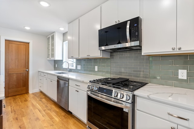 5345 45th Ave S, Minneapolis, MN 55417 - kitchen with stainless steel appliances, light wood-style flooring, white cabinetry, light stone countertops, and tasteful backsplash