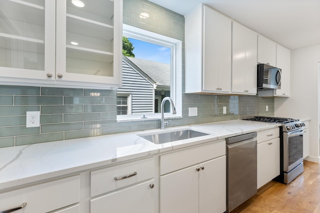 5345 45th Ave S, Minneapolis, MN 55417 - kitchen with appliances with stainless steel finishes, light wood-style flooring, white cabinetry, and tasteful backsplash