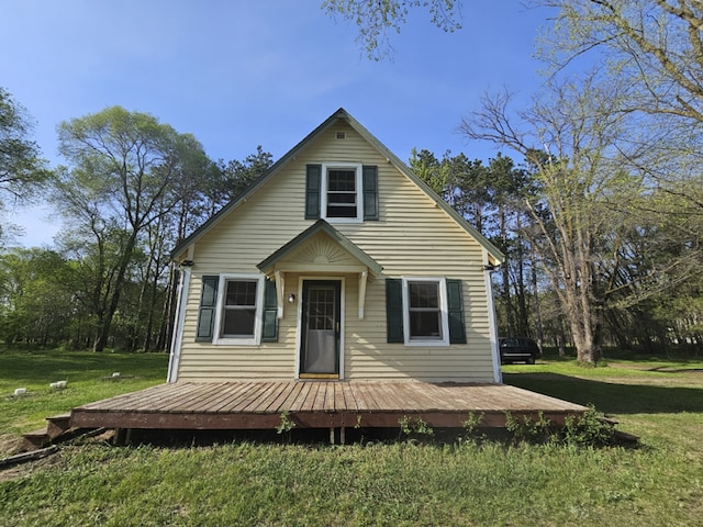 bungalow with a wooden deck and a front lawn