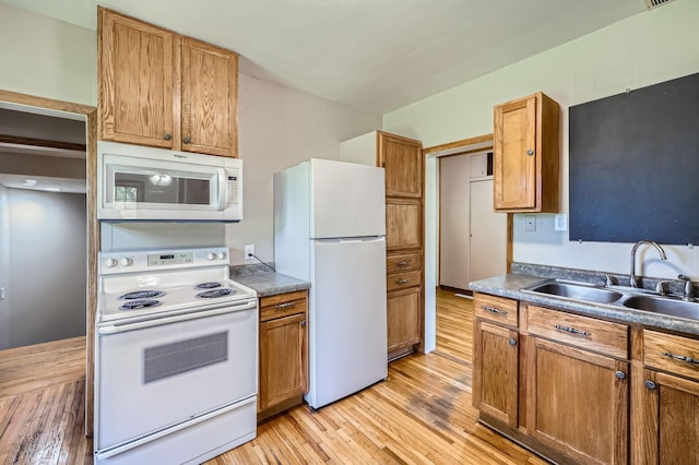 5159 Fawn Lake Dr NE, Linwood Twp, MN 55079 - kitchen with white appliances, a sink, light wood-style flooring, and brown cabinetry