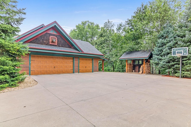 view of side of property with driveway and an outbuilding