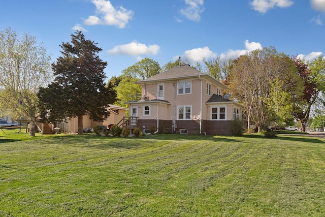 205 2nd St SW, Blooming Prairie, MN 55917 - rear view of property with a lawn and stucco siding