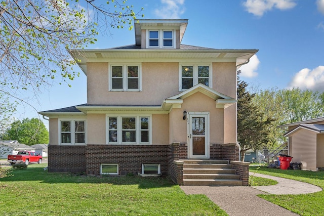 205 2nd St SW, Blooming Prairie, MN 55917 - american foursquare style home with stucco siding, a front yard, and roof with shingles