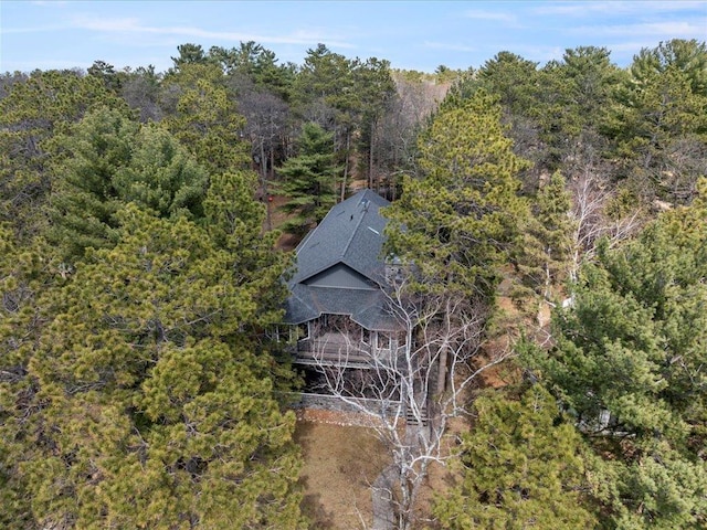 aerial view of property and surrounding area with a heavily wooded area