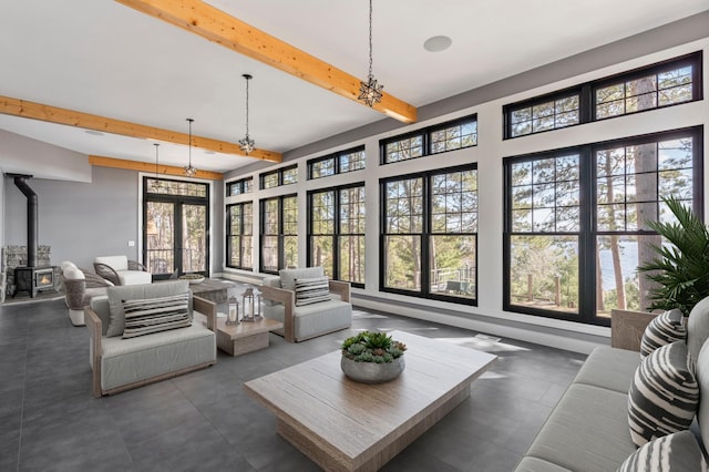 living room featuring beam ceiling and a wood stove