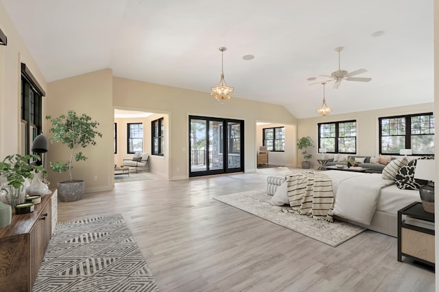 living room featuring lofted ceiling, light wood-type flooring, plenty of natural light, a ceiling fan, and baseboards