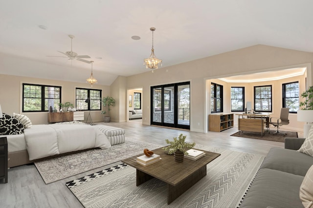 bedroom with vaulted ceiling, light wood-type flooring, multiple windows, and access to exterior