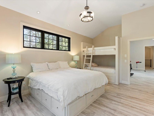 bedroom with light wood-style flooring, lofted ceiling, baseboards, and a chandelier