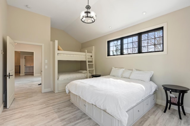 bedroom with lofted ceiling, light wood-type flooring, baseboards, and a chandelier