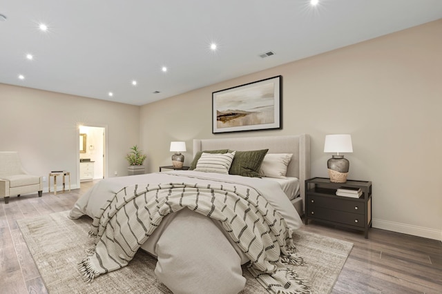bedroom featuring baseboards, wood finished floors, recessed lighting, and connected bathroom