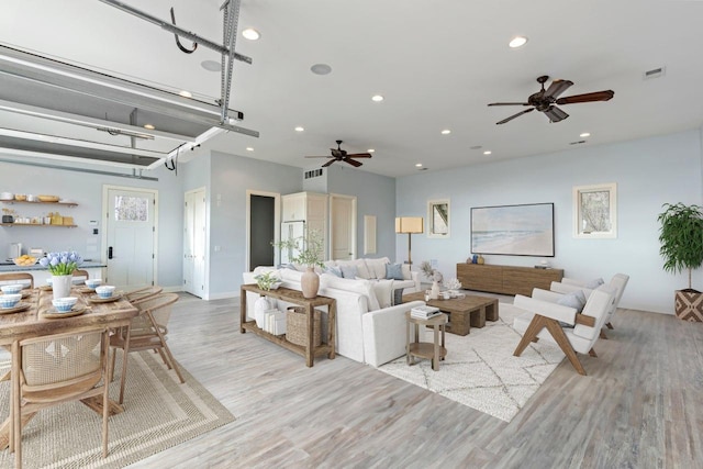 living area with a ceiling fan, light wood-type flooring, and recessed lighting