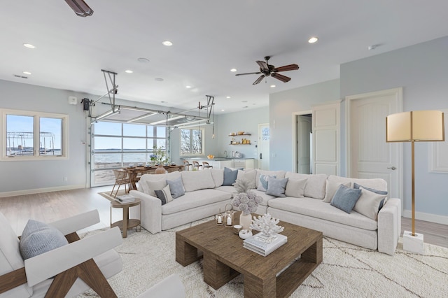 living area with recessed lighting, light wood-style floors, baseboards, and ceiling fan