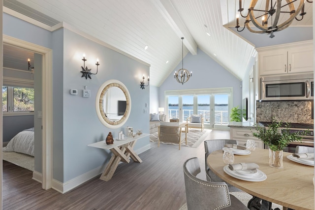 dining space featuring a chandelier, beamed ceiling, wood finished floors, healthy amount of natural light, and baseboards