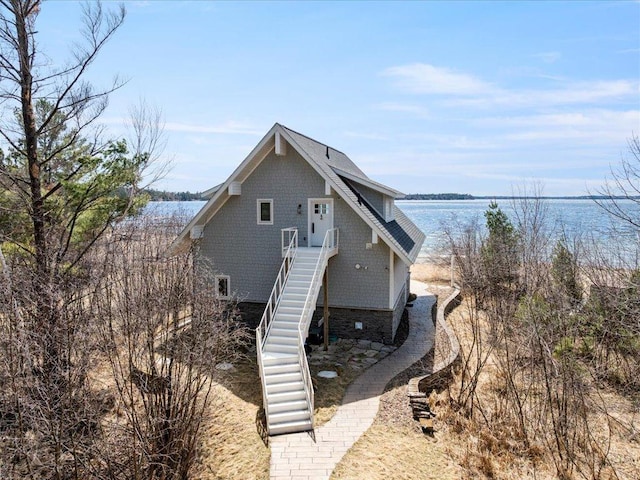 view of front of home with a water view and stairs