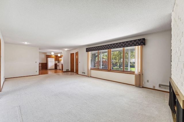 unfurnished living room with a fireplace, carpet floors, and a textured ceiling