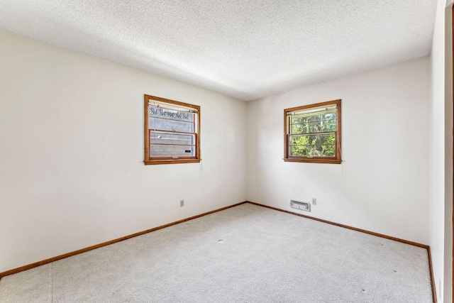 carpeted empty room featuring baseboards and a textured ceiling