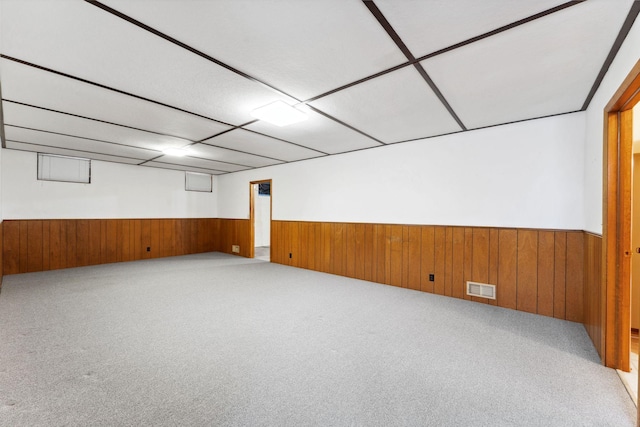 spare room with a wainscoted wall, carpet, and wooden walls