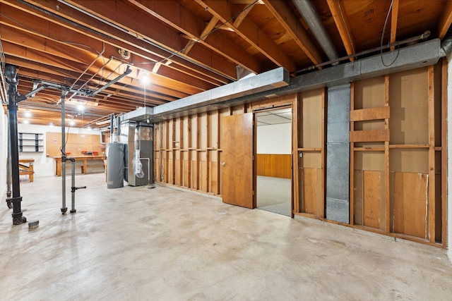 unfinished basement featuring water heater and heating unit