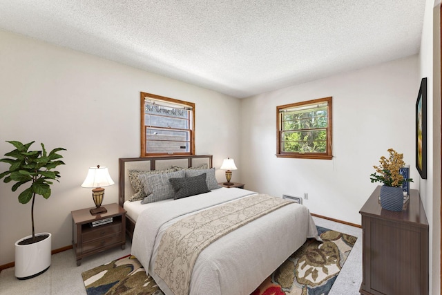 bedroom featuring carpet, multiple windows, baseboards, and a textured ceiling