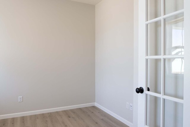 unfurnished room featuring baseboards and light wood-type flooring