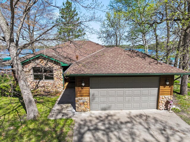10209 Amery Ave NW, Silver Creek Twp, MN 55362 - view of front of home featuring stone siding, roof with shingles, and an attached garage