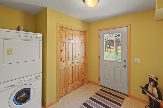 10209 Amery Ave NW, Silver Creek Twp, MN 55362 - clothes washing area featuring stacked washer / dryer, light tile patterned floors, and baseboards