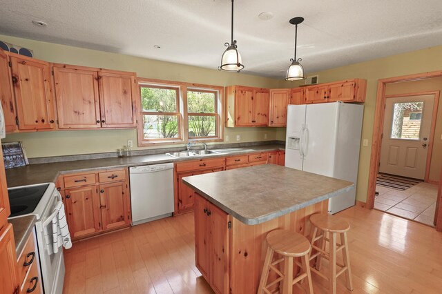 10209 Amery Ave NW, Silver Creek Twp, MN 55362 - kitchen featuring white appliances, a sink, light wood-style floors, and a center island