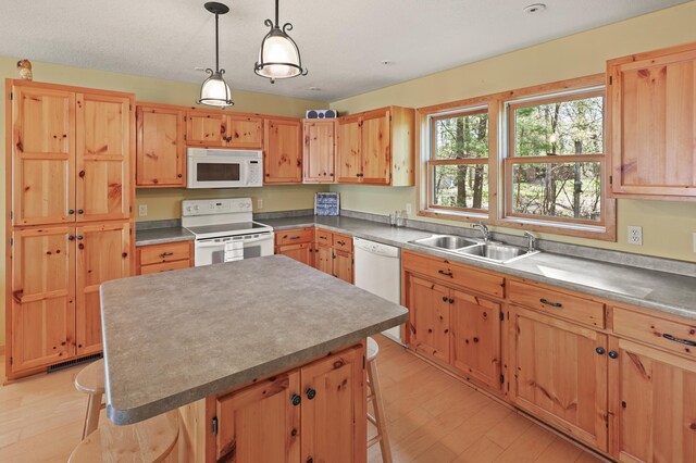 10209 Amery Ave NW, Silver Creek Twp, MN 55362 - kitchen with white appliances, a sink, light wood-type flooring, and a kitchen island