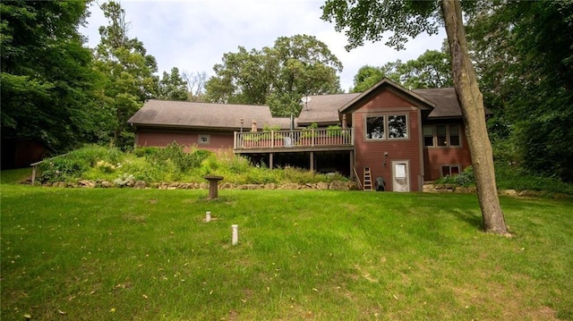 rear view of house with a lawn and a wooden deck
