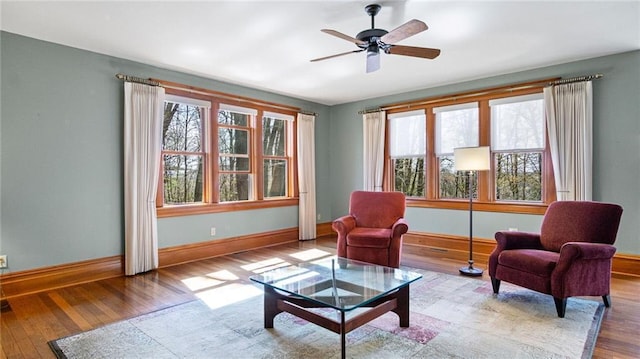 sitting room featuring baseboards, ceiling fan, and wood finished floors