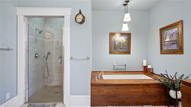 bathroom featuring a shower stall and a bath