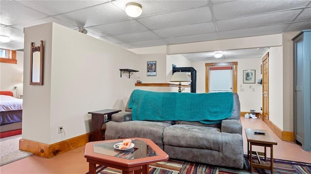 living room with baseboards and a drop ceiling