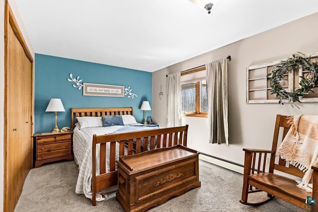 bedroom with a closet, carpet floors, and a baseboard heating unit