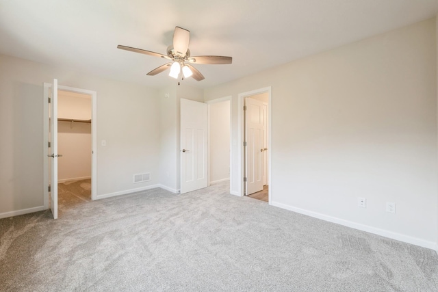 601 Harry Davis Ln, Minneapolis, MN 55411 - unfurnished bedroom featuring a walk in closet, carpet floors, baseboards, a ceiling fan, and a closet