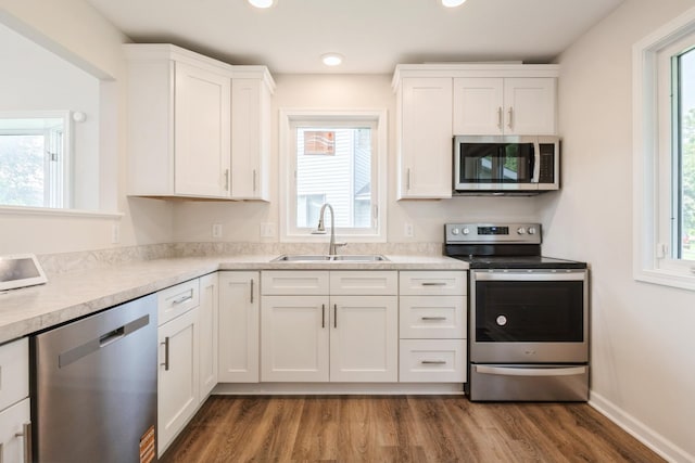 601 Harry Davis Ln, Minneapolis, MN 55411 - kitchen featuring stainless steel appliances, a sink, white cabinetry, healthy amount of natural light, and recessed lighting
