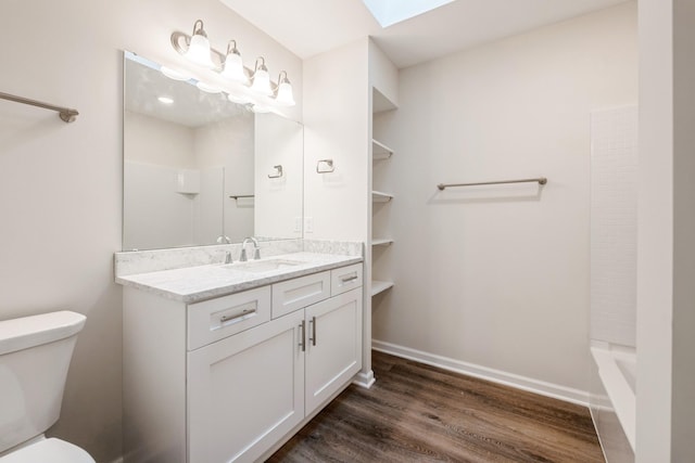 601 Harry Davis Ln, Minneapolis, MN 55411 - full bath featuring wood finished floors, toilet, vanity, a skylight, and baseboards