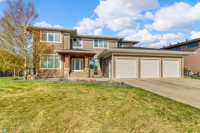 prairie-style house with an attached garage, driveway, a front yard, and stone siding