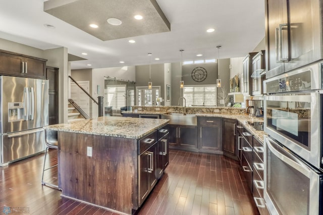 kitchen with a wealth of natural light, stainless steel appliances, a breakfast bar area, and a sink