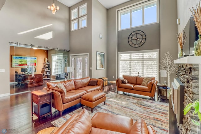 living area with baseboards, a wealth of natural light, and a towering ceiling