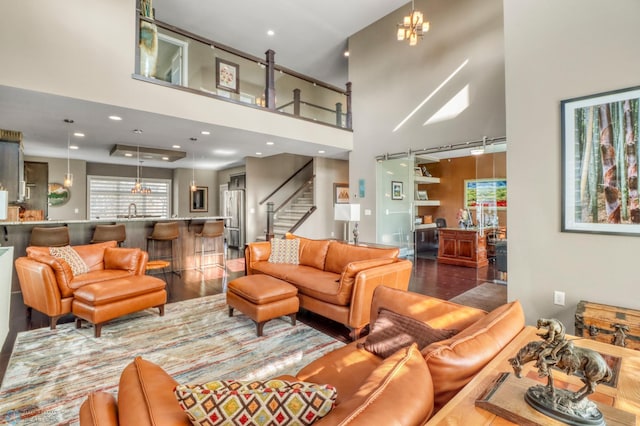 living area with stairway, recessed lighting, a towering ceiling, and wood finished floors