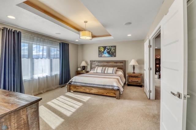 bedroom featuring a raised ceiling, recessed lighting, and light colored carpet